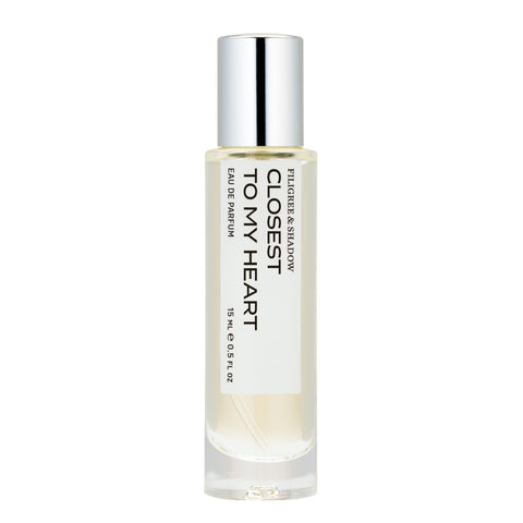 A sleek, cylindrical glass bottle of perfume labeled "Filigree & Shadow - Closest to My Heart - Eau de Parfum." The minimalist white label features bold, modern typography. The bottle is topped with a polished silver cap and contains a clear, pale-hued liquid. Capacity: 15 mL (0.5 fl oz).